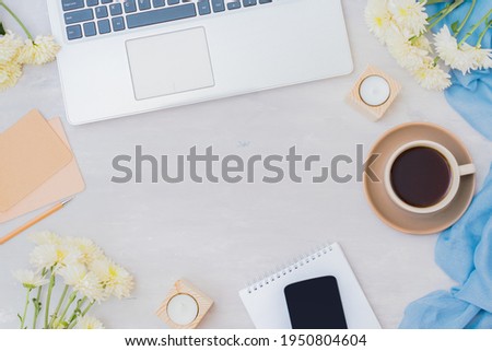Flat lay home office desktop with laptop, cup of coffee and white flowers on a light background