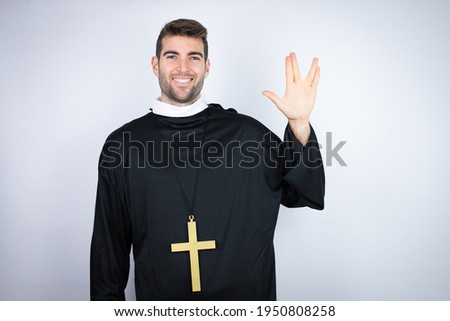 Young hispanic man wearing priest uniform standing over white background doing hand symbol