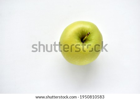 A bright green apple on a white background