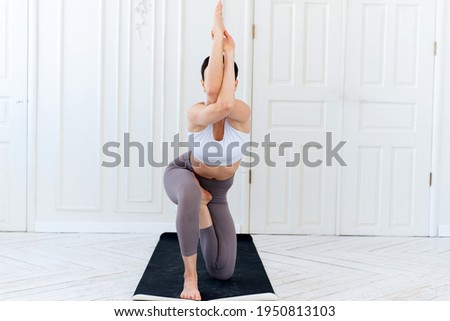 Young woman practicing yoga in a light background. Healthy lifestyle concept