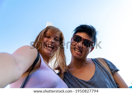 Young multi ethnic couple taking selfies.
