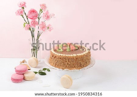 Cake with chocolate and meringue, marshmallows and flowers on a light table, festive food for mother's day, wedding, birthday. Modern bakery concept, selective focus, delicious dessert.