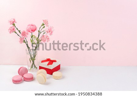 Colorful macaroons and flowers on a light table, festive food for mother's day, wedding, birthday. Modern bakery concept, selective focus, delicious dessert. Business card for a restaurant
