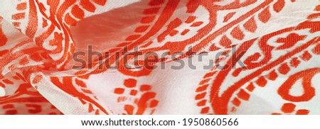 Silk fabric, ruby red shades of delicate exquisite colors on a white background, photo of a Paisley print. Texture, pattern, collection