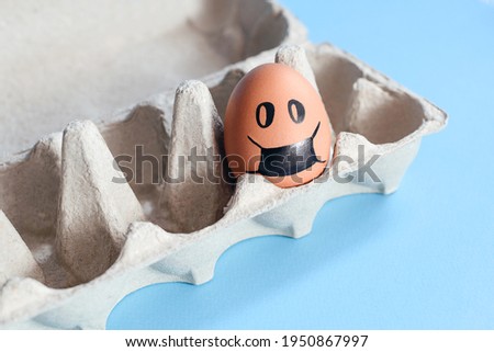 One easter egg in a drawing medical mask in box. Self-isolation concept.