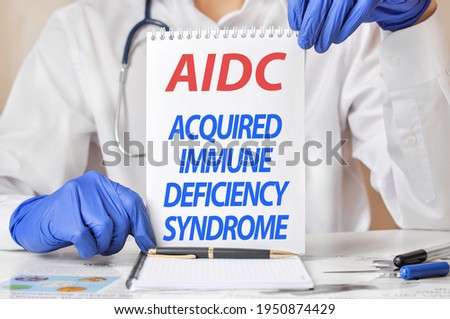 Doctor's hands in blue gloves holding a sheet of paper with text aids. aids - short for acquired immune deficiency syndrome, medical concept