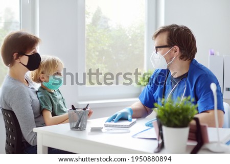 Little boy with mother at doctor's appointment during coronavirus epidemic. Pediatrician examining child and preparing to give a injection vaccine against covid-19. Vaccination of kids. Herd immunity