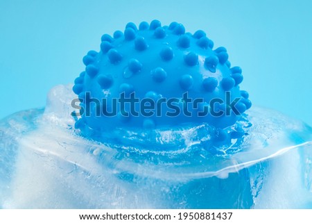 Pathogen trapped in the permafrost, microbiology and infectious disease concept with virus frozen in block of melting ice isolated on blue background Royalty-Free Stock Photo #1950881437