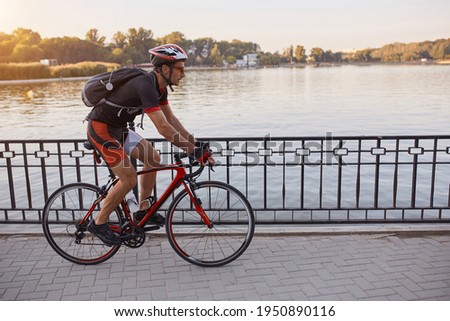 Young man are cycling road bike by the lake in the park