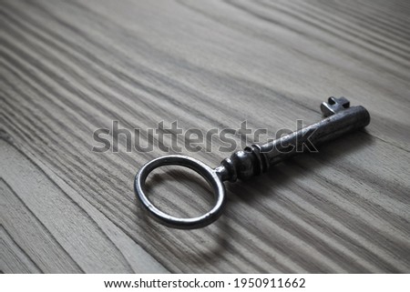 Old fashioned metal key on a wooden table