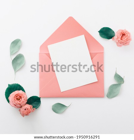 Flat lay shot of letter and envelope on white background. Wedding invitation cards or love letter with pink roses. Valentine's day or mother day holiday concept, top view, flat lay, overhead view Royalty-Free Stock Photo #1950916291