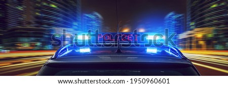 Police car with blue lights at night in a city