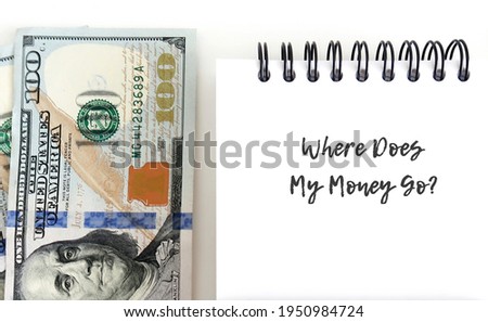 Dollars cash money with notebook and handwritten question WHERE DOES MY MONEY GO? , concept of financial management , try to find money leaks , track spending , set budget and boost saving