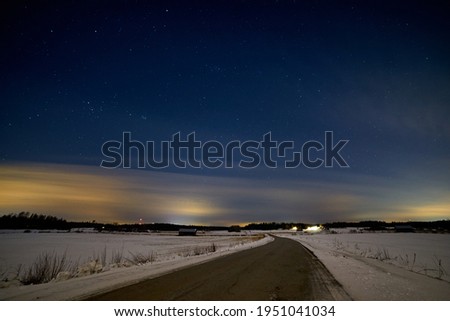  Road between snowy fields at night                               