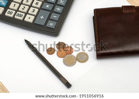 small coins wallet calculator and fountain pen on sheets of white paper on the table concept business budget economy. High quality photo