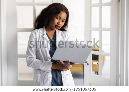 Handsome contented African American female doctor working on a laptop. telemedicine