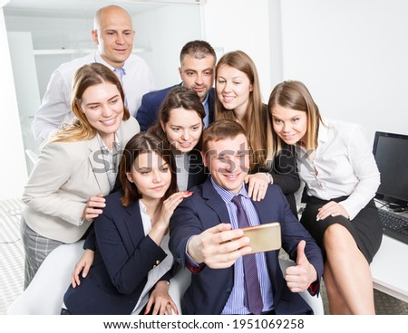 Happy cheerful business group taking selfie in office space