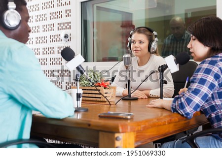 Presenters of different nationalities in sound broadcasting station hosting live radio show