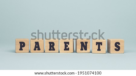 The word PARENTS made from wooden cubes on blue background. Conceptual photo