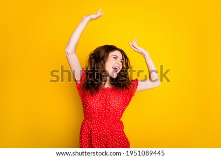 Photo portrait of happy girl with wavy hair in red dress laughing dancing at party looking copyspace isolated vivid yellow color background