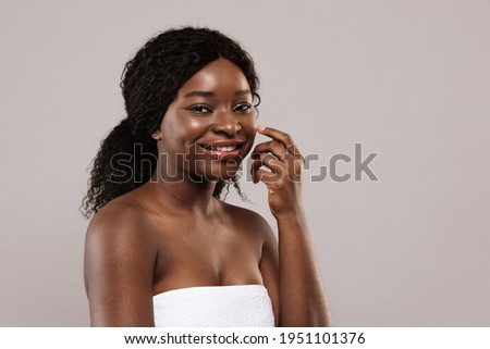 Skin Care Treatments. Portraif Of Beautiful African American Female Wrapped In Towel Posing After Spa Procedures Over Grey Background, Pretty Black Woman Looking And Smiling At Camera, Copy Space
