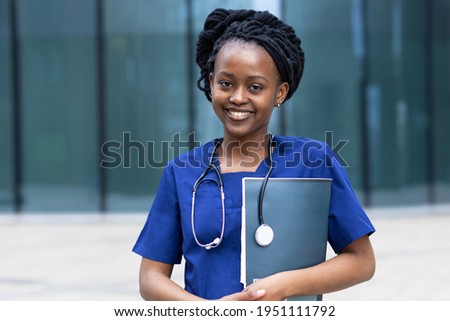 portrait of laughing young black lady doctor with stethoscope, trendy african american woman with dreadlocks in uniform, smiling afro girl medical student  at college, university, hospital, clinic Royalty-Free Stock Photo #1951111792