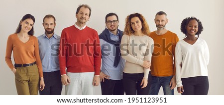 Banner with team of confident diverse people standing together. Group portrait of happy mixed race male and female models of different ages in comfortable smart casual wear posing in studio