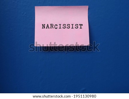 Pink note on copy space blue wall with text NARCISSIST , type of personality disorders, self-centered people, inflated of self importance , need attention and admiration , lack empathy to others Royalty-Free Stock Photo #1951130980
