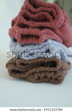 close-up of pet pants in different colors: yellow, pink, brown, blue