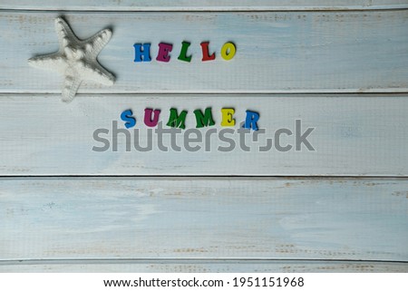 word hello summer is made up of volumetric color letters on a light blue wooden background, white starfish, summer time concept, vacation time, travel, boat trip, beach experience