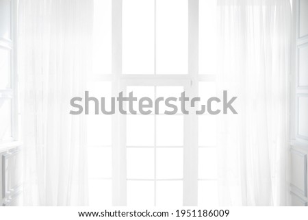 Backlit window with white curtains in empty room Royalty-Free Stock Photo #1951186009
