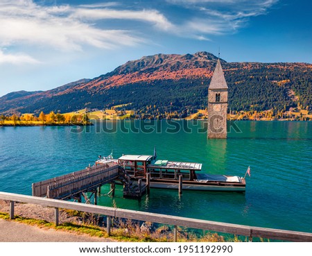 Landscape photography. Adorable autumn view of Tower of sunken church in Resia lake. Wonderful morning scene of Italian Alps, South Tyrol, Italy, Europe. Traveling concept background.