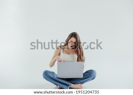 Freelance or work at home laptop. Beautiful woman in casual sit on floor and work with portable computer with crossed legs