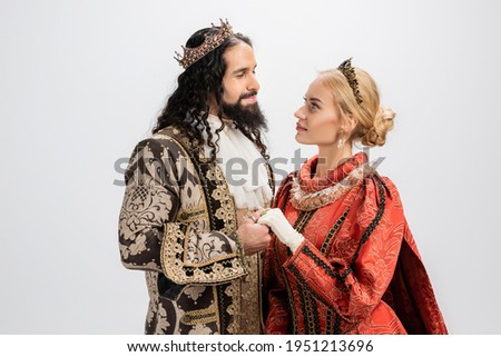 historical multiethnic couple in crowns and medieval clothing isolated on white