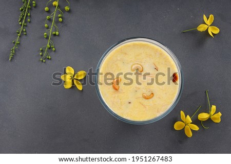 Vermecelli Payasam or Kheer ,South Indian main sweet dish made using vermicelli ,milk,sugar and dry nuts  and beautifully arranged with golden shower flower in the grey background, selective focus.