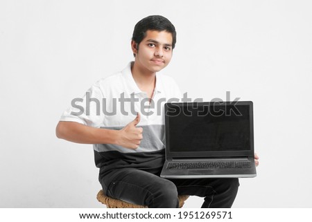 Indian college student showing laptop screen on white background.