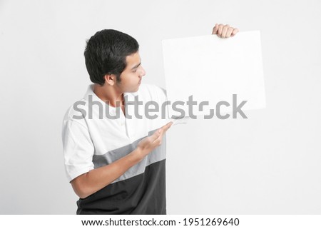 Young indian college student showing white board on white background