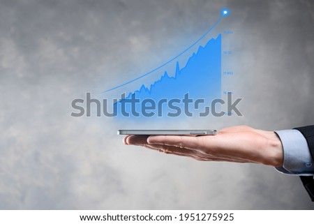 Businessman holding graph growth and increase of chart positive indicators in his business.Investment up concept.analyzing sales data and economic,strategy and planning, Digital marketing and stock 