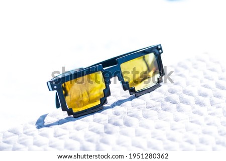 Yellow lenses pixel 8bit sunglasses design shoot in a summer day closeup. Selective focus