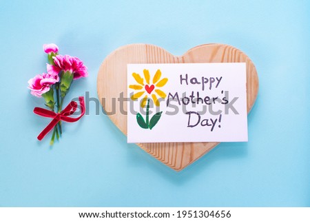 Mother day card, bouquet carnation, heart wood . Text Happy Mothers day. On a colored background. Postcard made by the kids for mom.