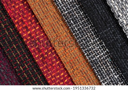 Multi-colored samples of woven textiles. Catalog and palette tone of Interior fabric for furniture, closeup. Collection of multicolored cloth with wicker pattern.