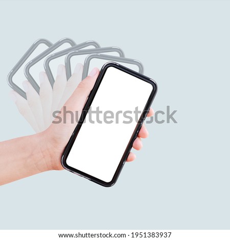 Close-up of male hand holding smartphone with mockup on pastel blue background.