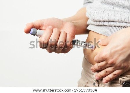 Young woman doing insulin injection pen, close-up. Diabetic patient with insulin pen for control diabetes. Royalty-Free Stock Photo #1951390384