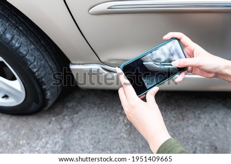 A woman using a mobile phone Take photos of the damage of the car, Which caused by a crash accident As evidence for insurance agents, to people and transportation insurance concept.