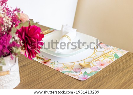 Plate with utensils, on the table decorated with a small flower arrangement