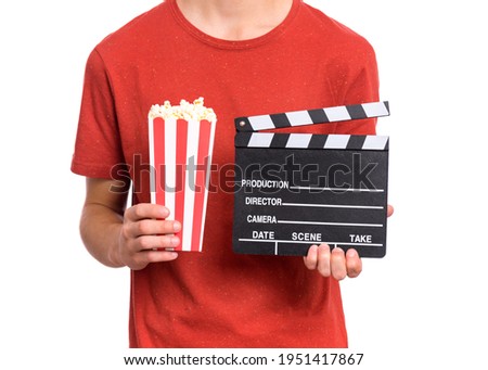 Teen boy hands with popcorn bucket, isolated white background. Child preparing to watch the film while holding popcorn. Close-up photo