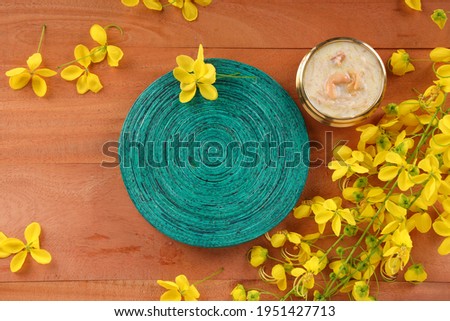 Vermecelli Payasam or Kheer ,South Indian main sweet dish beautifully arranged in a brass vessel with green round base placed near by and  golden shower flower in the wooden background,selective focus