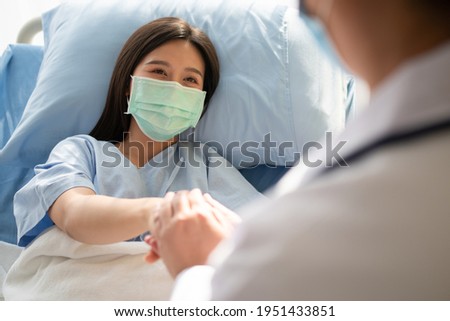 Women Asian doctors hold the patient hand and encourage and provide medical advice While checking the patient health in bed. Concept of Care and compassion Royalty-Free Stock Photo #1951433851