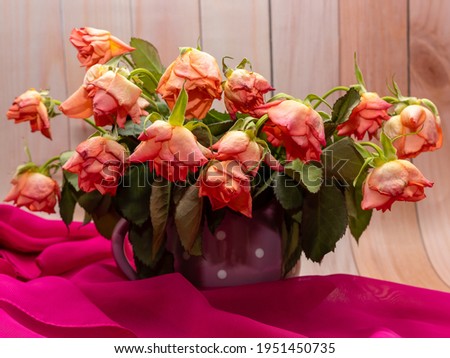 Bouquet of wilted roses in a clay mug. Memories, nostalgia, melancholy. Storage of beautiful, romantic memories. Selective focus.
