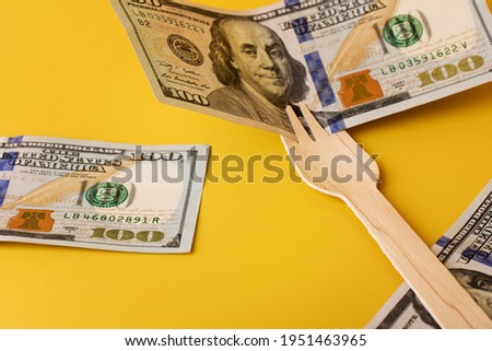 Hundred dollar bills on wooden fork. Natural eco friendly utensil. Business concept background.